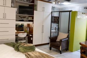 a room with a bed and a chair and a desk at Rustic Forest Guest House in Cerillio