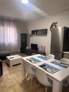 a kitchen with a table with chairs and a refrigerator at Adrian Apartment in Orikum