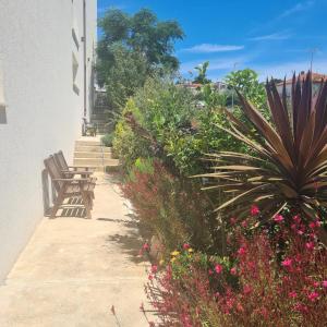 a walkway with a bench and some plants and flowers at Villa Queen in Zadar
