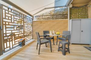 a dining room with a table and chairs and a screen at Diamond & Pearl Studios in Perea