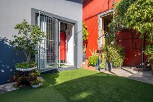 un cortile con erba verde e una casa rossa di Studio47 a Despatch