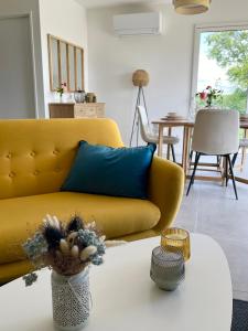 a living room with a yellow couch and a table at Villa moderne vue exceptionnelle et SPA in Villetoureix
