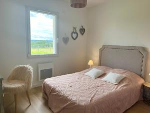 a bedroom with a bed with a window and a chair at Villa moderne vue exceptionnelle et SPA in Villetoureix +22 photos