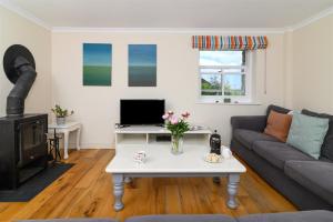 a living room with a couch and a table at Mousehole Cottage in Penzance