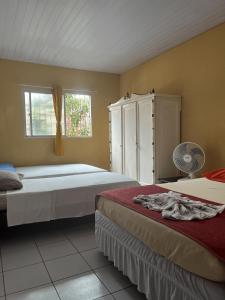 een slaapkamer met twee bedden en een ladekast bij Maragogi - Casa com piscina in Maragogi