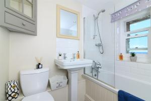 a bathroom with a toilet and a sink and a shower at Mousehole Cottage in Penzance +27 photos