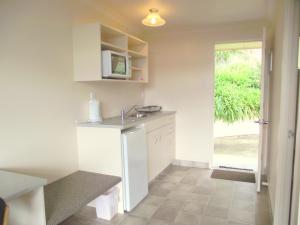 a small kitchen with a sink and a microwave at Panorama Motor Inn in Te Kuiti