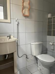 een witte badkamer met een toilet en een wastafel bij Maragogi - Casa com piscina in Maragogi