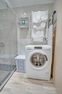 a washing machine in a bathroom with a shower at Diamond & Pearl Studios in Perea