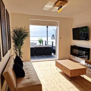 a living room with a couch and a table at Stunning Beachfront House, Herne Bay, Kent in Kent