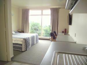 a bedroom with a bed and a large window at Panorama Motor Inn in Te Kuiti