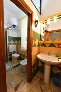 a bathroom with a sink and a toilet at B&B Tredomus in Tresnuraghes +59 photos