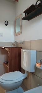 a bathroom with a white toilet and a mirror at Los Ceibos Suites in Villa Ciudad de America