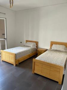 Appartement a saidia 100m tout pret de la plage في السعيدية: سريرين يجلسان بجانب بعضهما البعض في غرفة +3 صور