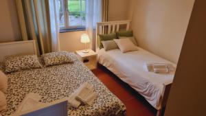 two beds in a small room with a window at Apartamento Moura - Praia D’El Rey Golf, Surf & Beach Resort in Casal da Lagoa Seca +36 photos