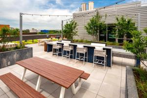 un patio con una mesa de madera y un bar en la azotea en Prime Metro Proximity - Condo at Clarendon, en Arlington