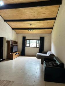 a large living room with a couch and a tv at Sitio Tripans Paraiso dos Sonhos in Igaratá
