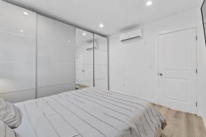 a white bedroom with a bed and a shower at Muirfield Chic City Bungalow with Parking in Los Angeles