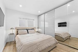 a bedroom with two beds and a glass wall at Muirfield Chic City Bungalow with Parking in Los Angeles
