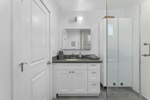 a white bathroom with a sink and a mirror at Muirfield Chic City Bungalow with Parking in Los Angeles +41 photos