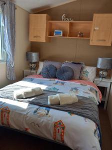 a bedroom with a large bed with pillows on it at Tunstall J&D Caravan on the East Coast in Tunstall