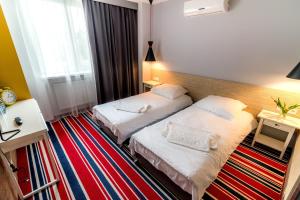 una camera d'albergo con due letti e una finestra di Tamada a Ozorków