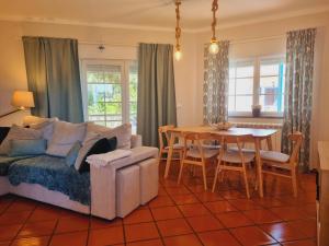 a living room with a couch and a dining room table at Apartamento Moura - Praia D’El Rey Golf, Surf & Beach Resort in Casal da Lagoa Seca