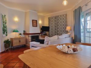 a living room with a couch and a table at Apartamento Moura - Praia D’El Rey Golf, Surf & Beach Resort in Casal da Lagoa Seca