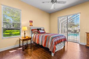 a bedroom with a bed and a table with a lamp at Quiet and Cozy 3 beds 3 baths in Spring Hill with heated Pool and Hot Tub in Spring Hill +15 photos