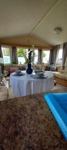 a living room with a table with flowers on it at Tunstall J&D Caravan on the East Coast in Tunstall +11 photos