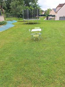 a table and chairs sitting in a field of grass at Belle Maison Récente in Neauphle-le-Château