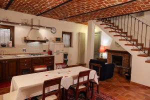 a kitchen and dining room with a table and a staircase at Casa immersa nella natura in CastellʼAlfero