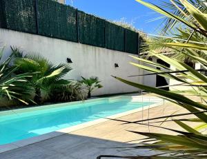a swimming pool in front of a fence at Villa des Perdrix - Piscine et Clim - 120m2 in Lavalette