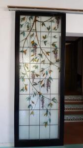 een glazen frame met een boom muurschildering op een muur bij Ca' da Mariolina in Carloforte