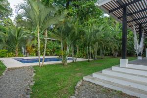 a group of palm trees next to a swimming pool at Tres Lodge- Private Pool - Nature and Comfort for Groups in Cocles