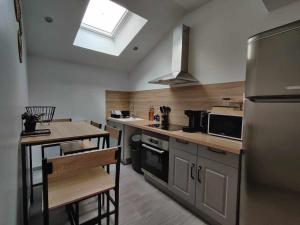 a kitchen with a refrigerator and a table in it at La Petite Falaise, maison avec cour Dreux centre in Dreux