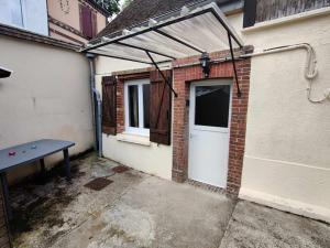 a garage with a white door and a picnic table at La Petite Falaise, maison avec cour Dreux centre in Dreux