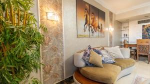 a living room with a couch and a plant at Duplex-Nyoum New Cairo in Cairo