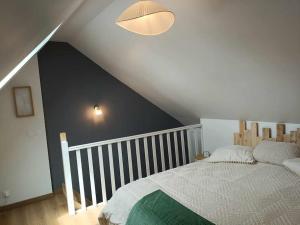 a bedroom with a white bed with a black wall at La Petite Falaise, maison avec cour Dreux centre in Dreux