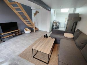 a living room with a couch and a table at La Petite Falaise, maison avec cour Dreux centre in Dreux