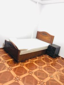 a bed in a room with a wooden floor at Maria Apartment in Alexandria