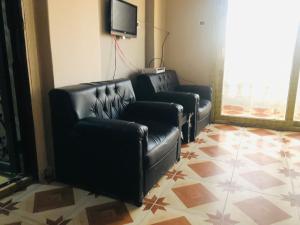 a living room with leather couches and a flat screen tv at Maria Apartment in Alexandria