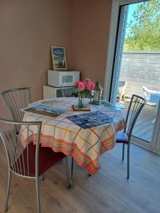 a dining room table with a vase of flowers on it at Romanjo in Agon Coutainville