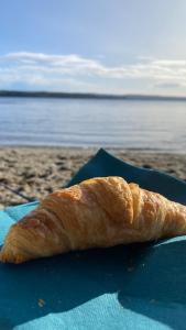 a piece of bread sitting on a blue plate on the beach at Fornebu Holtekilen panorama in Stabekk