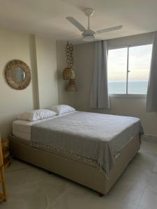 um quarto com uma cama e uma janela com o oceano em Ap centro de Guarapari com as melhores vistas!!! em Guarapari