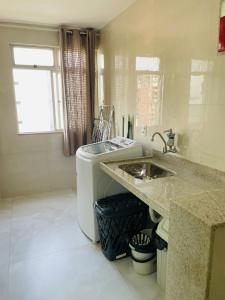 uma cozinha com pia e máquina de lavar em Ap centro de Guarapari com as melhores vistas!!! em Guarapari mais 25 fotografias