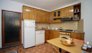 培拉特Villa Decolli的配有木质橱柜和白色冰箱的厨房