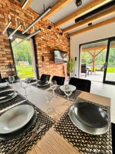 a dining room with a table with plates and wine glasses at GrandBytyń House in Nakielno