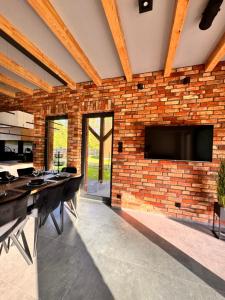 a brick wall with a flat screen tv on a wall at GrandBytyń House in Nakielno