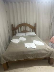 a bed with white towels on top of it at Hotel Pousada Irmaos Freyhardt in Rio de Janeiro